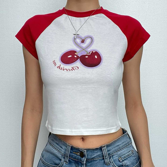 Top corto con scollo rotondo e maniche a cappuccio a contrasto con motivo patchwork di ciliegie 
