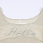 Top corto con scollo a U testurizzato e maniche svasate con motivo "Hello"