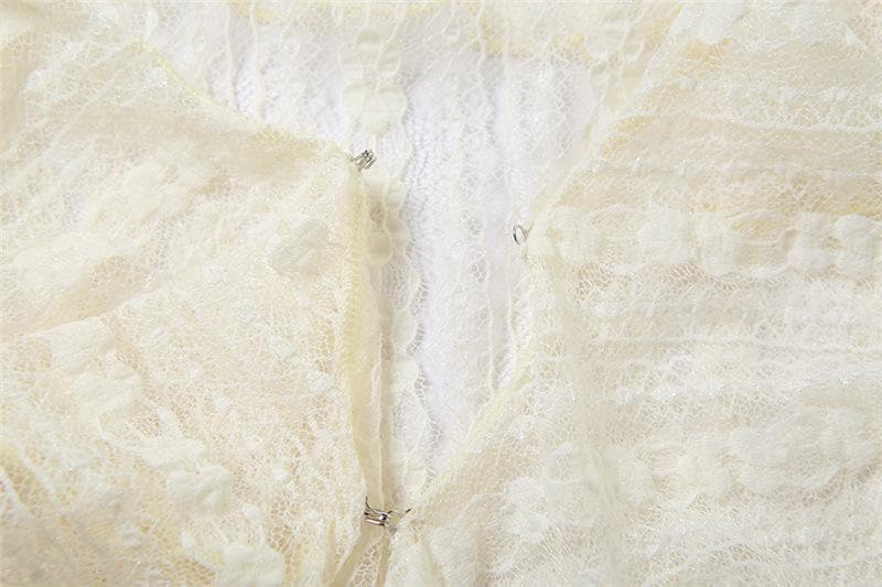 Top corto in pizzo trasparente con maniche svasate, scollo a V, volant e bottoni tinta unita 