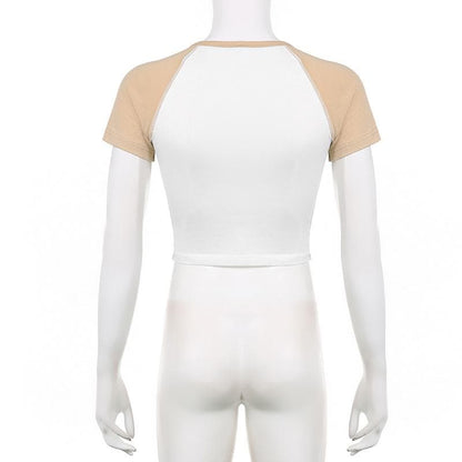 Top corto a maniche corte con scollo a giro e contrasto astratto con patchwork di punti 